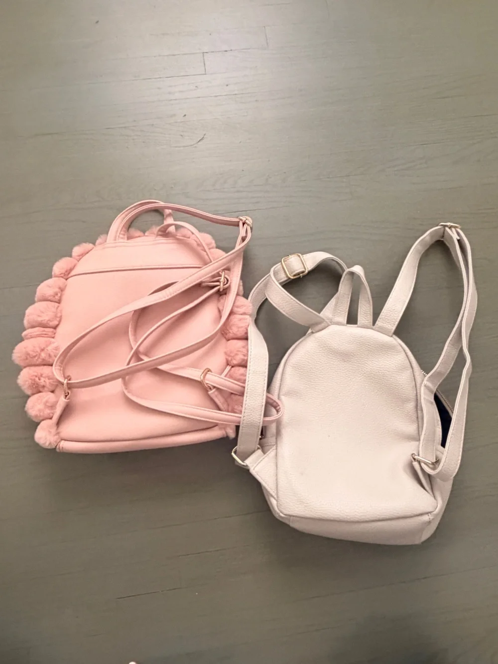 Two cute mini backpacks, one pink fuzzy, one white